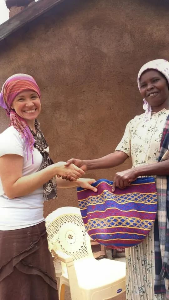 Christin sharing a handmade bag with a woman in Kenya