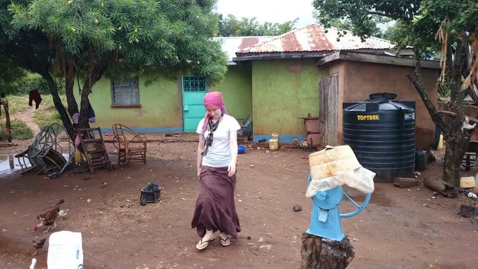 Christin walking through a family home in Kenya