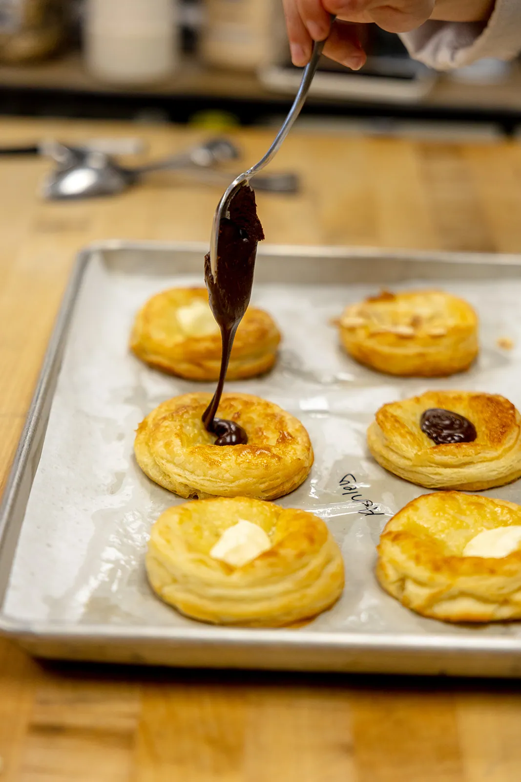 Chocolate danishes being finished by hand in Manna Bakery
