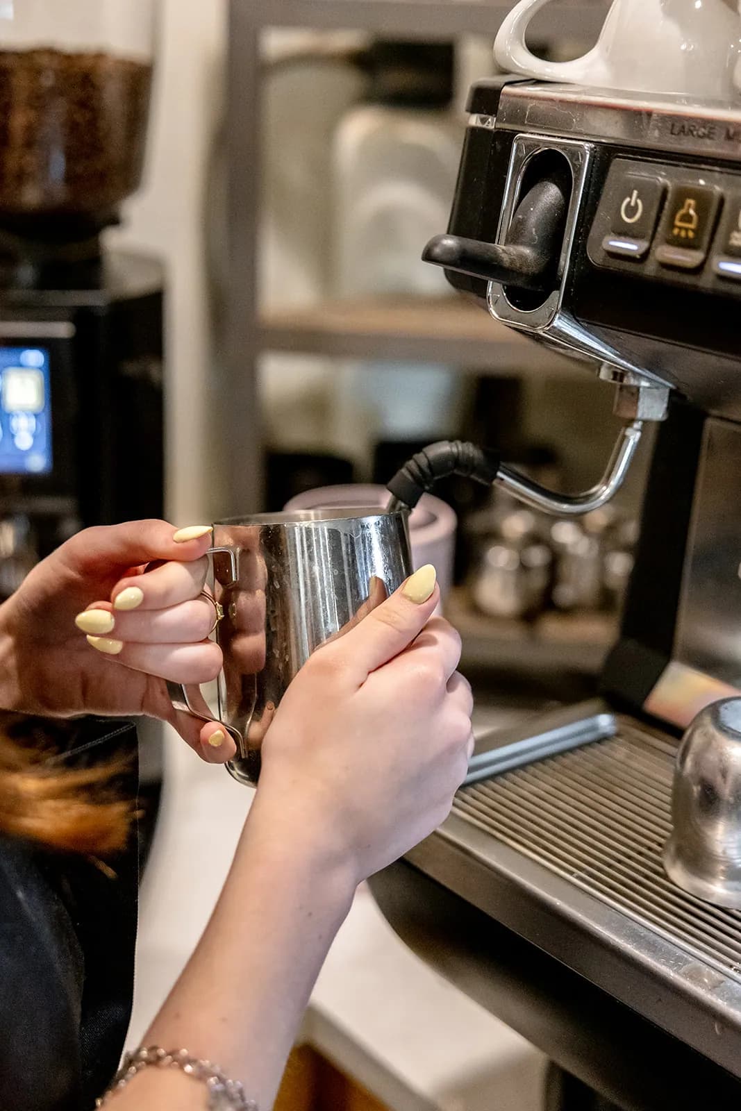 A Manna barista steaming milk at the espresso machine